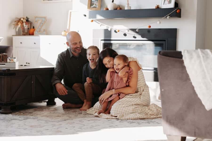 Family enjoying quality time together in a cozy living room, surrounded by autumn decor and a warm fireplace, reflecting themes of togetherness and home.